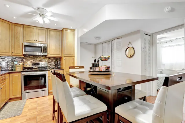 a kitchen with stainless steel appliances a stove a sink a microwave a refrigerator and cabinets