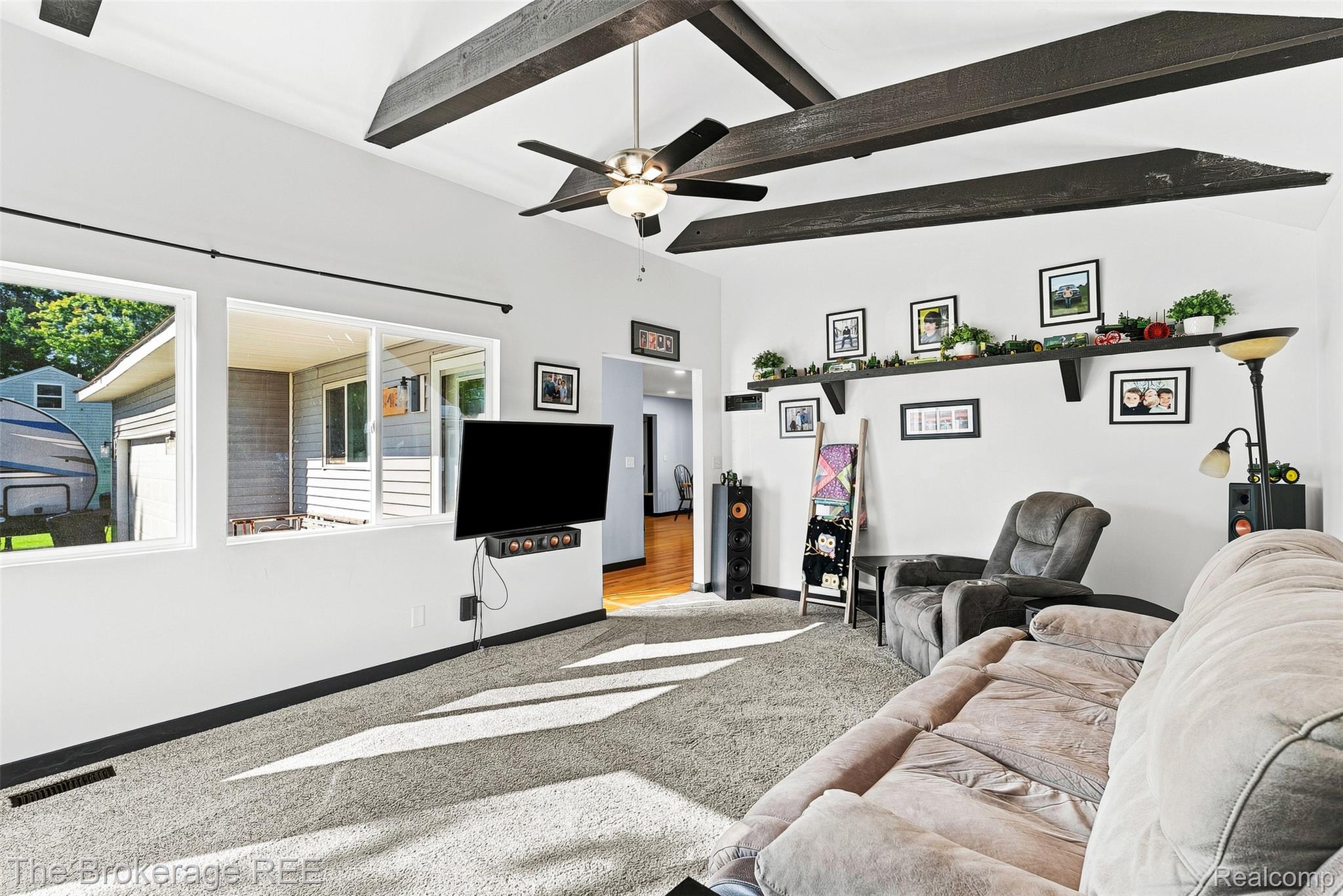 4443 North Gale Road Davison, MI 48423 - Photo 13 of 36 Vaulted ceiling with exposed wood beams, ceiling fan, multiple windows, and wall-mounted shelving