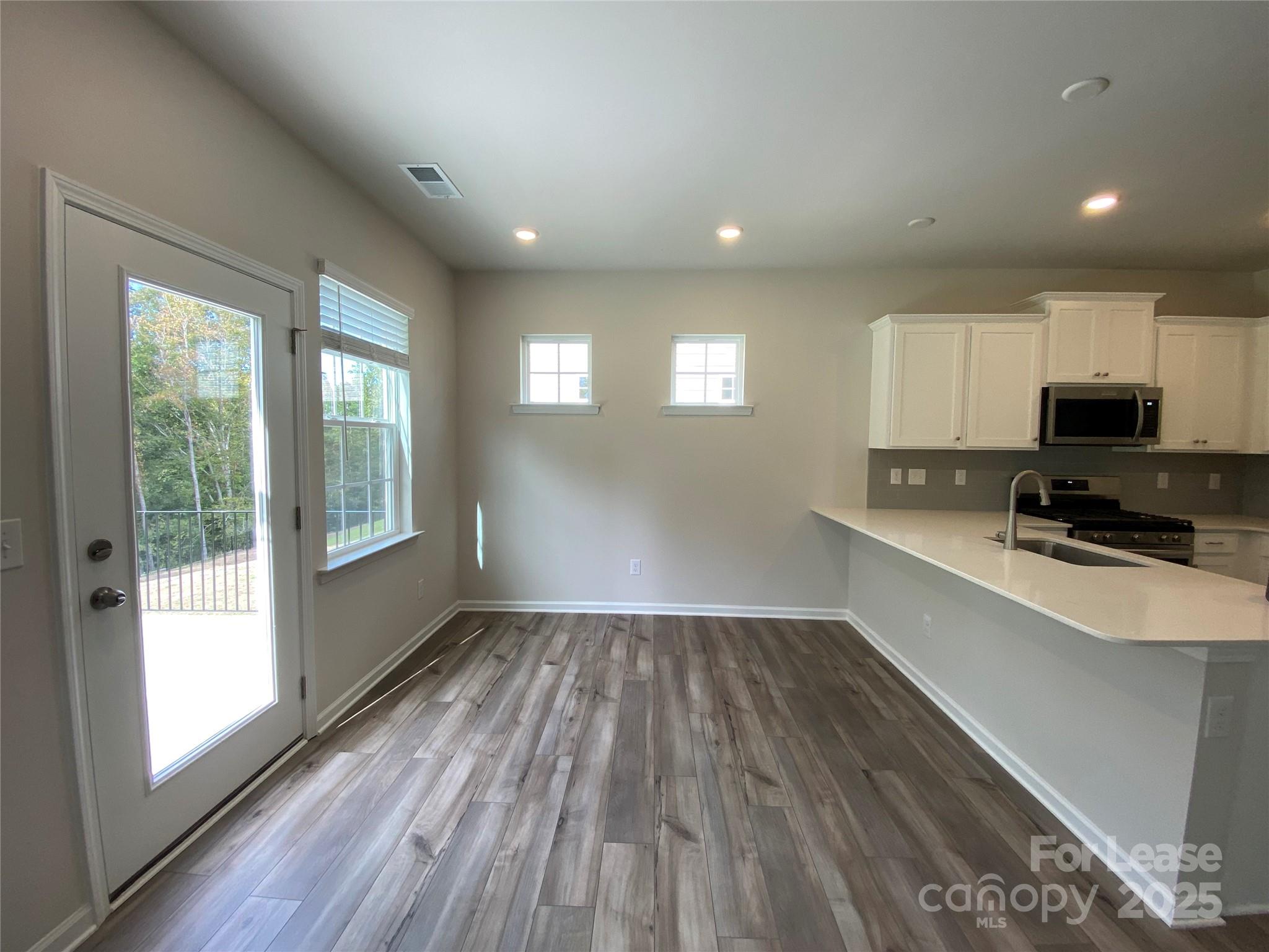 18219 Stark Way Charlotte, NC 28278 - Photo 13 of 42 a view of kitchen and microwave with wooden floor