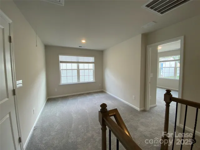 a view of a livingroom with wooden floor and furniture