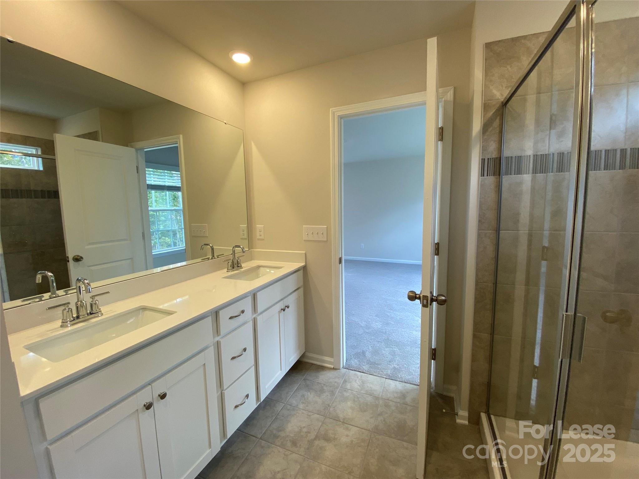 18219 Stark Way Charlotte, NC 28278 - Photo 23 of 42 a spacious bathroom with a double vanity sink a mirror and a shower