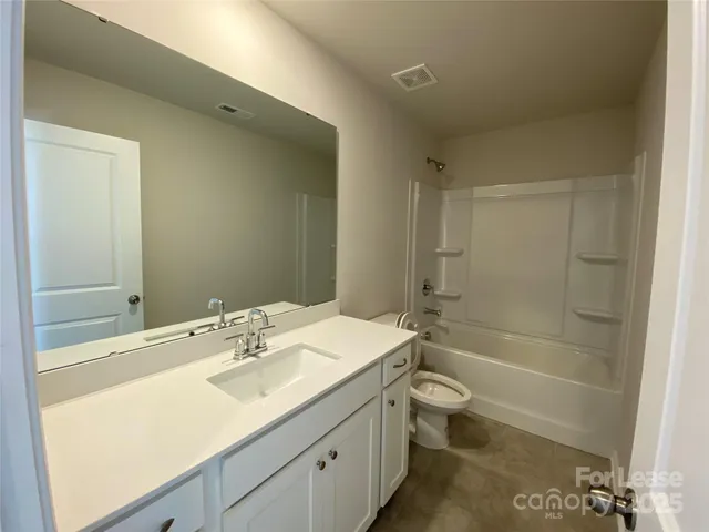 an empty room with closet and mirror