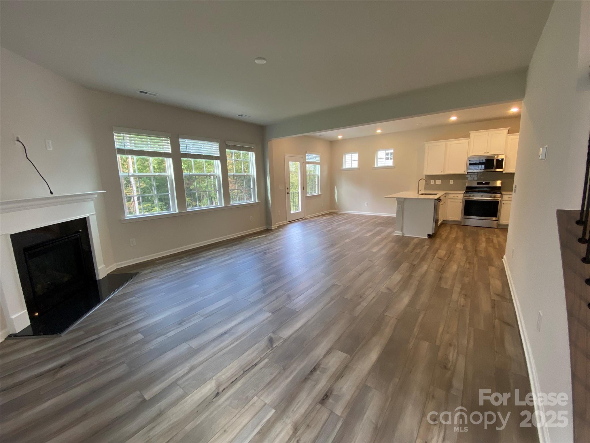 18219 Stark Way Charlotte, NC 28278 - Photo 4 of 42 a view of empty room with wooden floor and fireplace