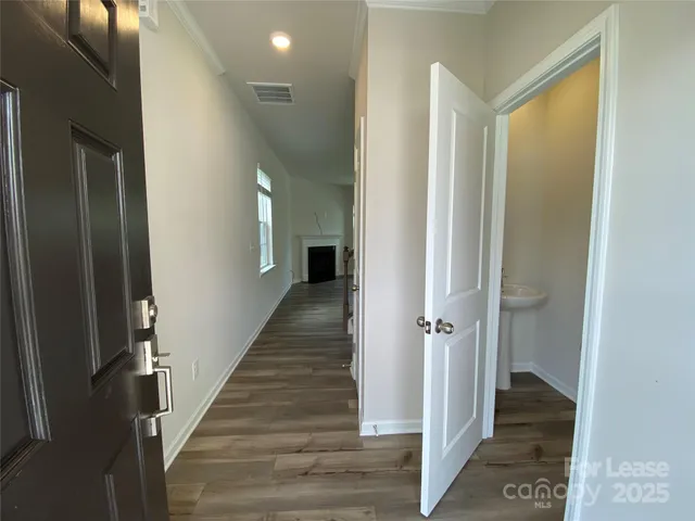 a view of a hallway with wooden floor and staircase