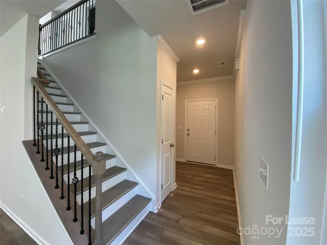 a view of a hallway with wooden floor and entryway