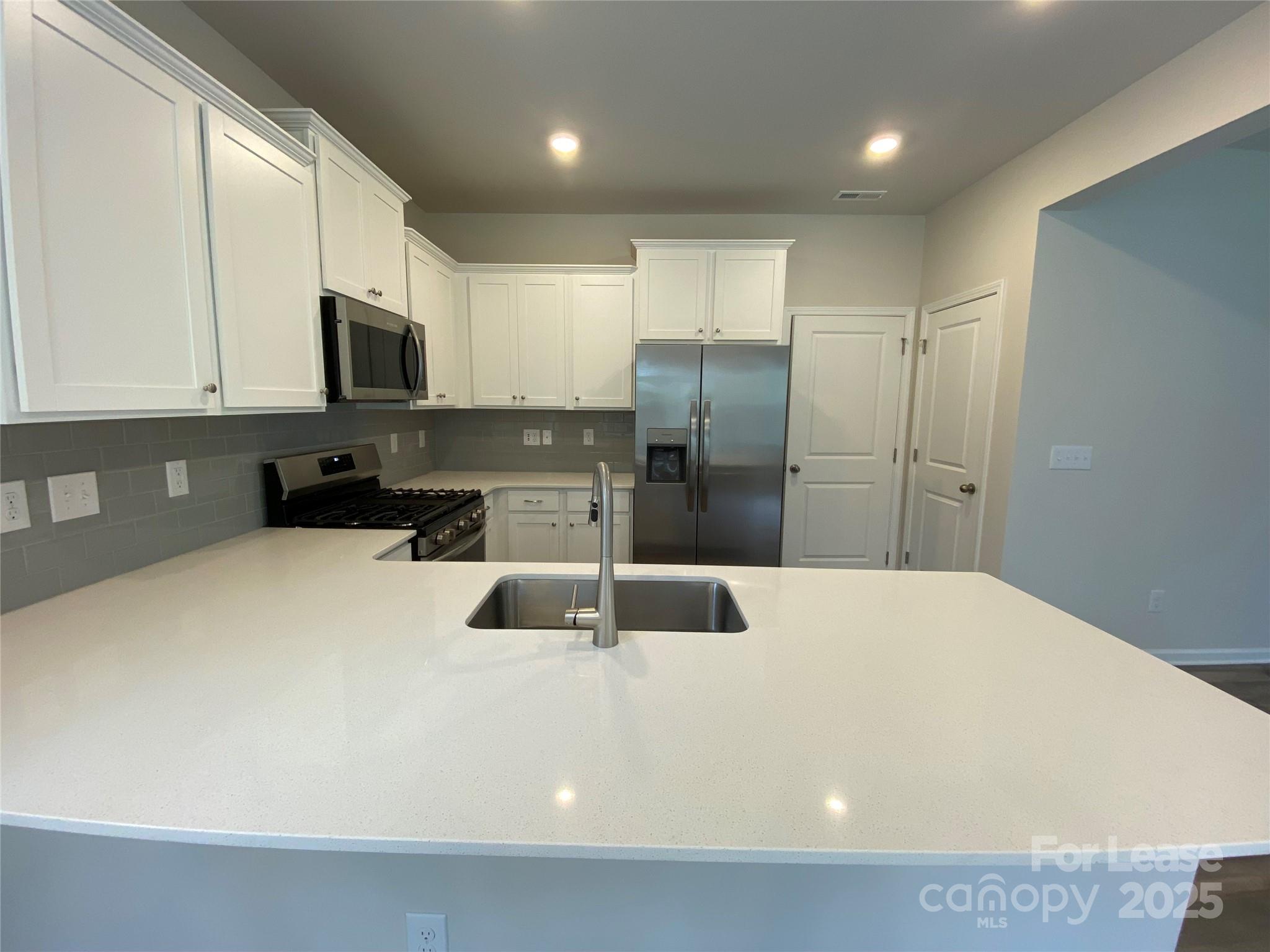 18219 Stark Way Charlotte, NC 28278 - Photo 9 of 42 a kitchen with stainless steel appliances a refrigerator sink microwave and cabinets