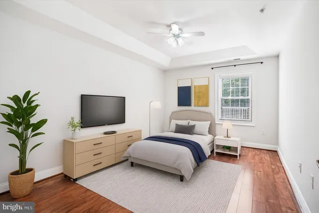 a spacious bedroom with a bed and a flat screen tv