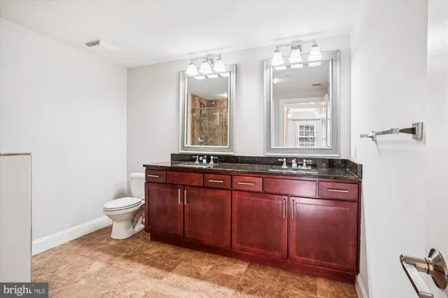 a bathroom with a toilet sink and mirror