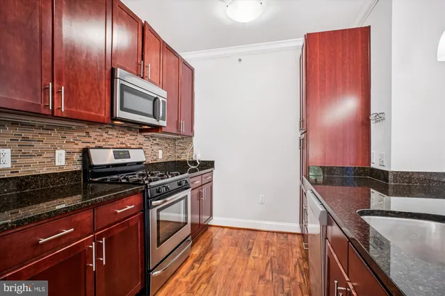 a kitchen with granite countertop wooden cabinets and stainless steel appliances
