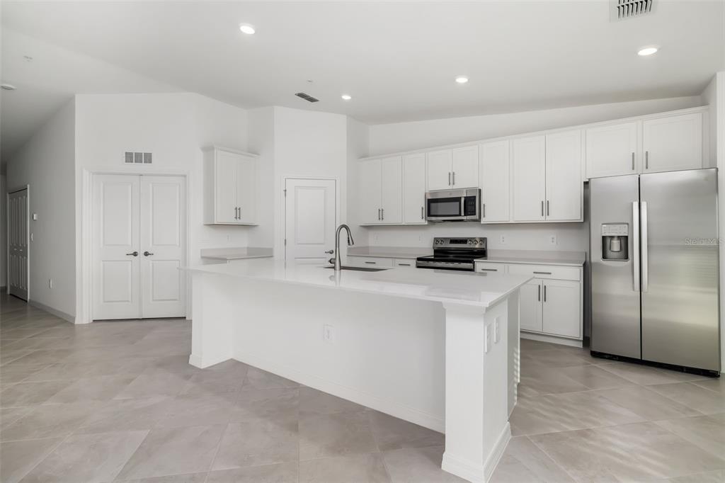 19015 Scallop Loop, Unit 204 Lakewood Ranch, FL 34211 - Photo 8 of 56 a kitchen with stainless steel appliances granite countertop a refrigerator stove a sink and a microwave