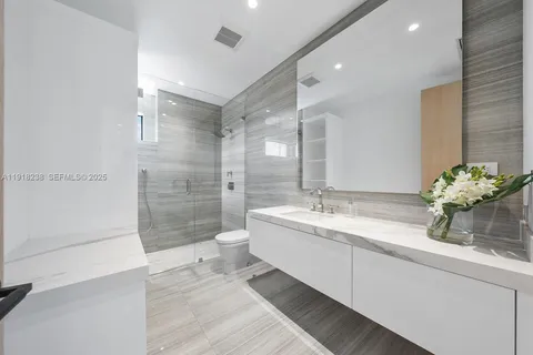 a spacious bedroom with a bed and a flat screen tv