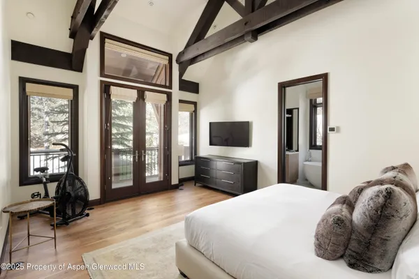 a bedroom with a large bed and a flat tv screen on dresser