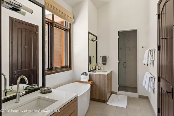 a bathroom with a double vanity sink a mirror and a bathtub