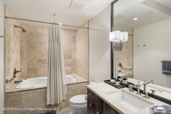a bathroom with a sink toilet tub and shower