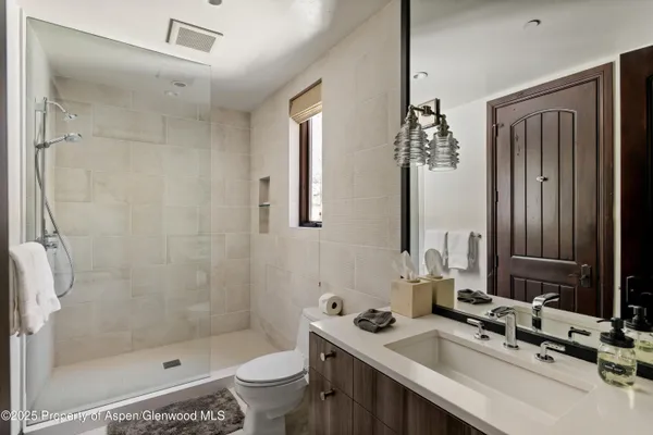 a bathroom with a sink a toilet and shower