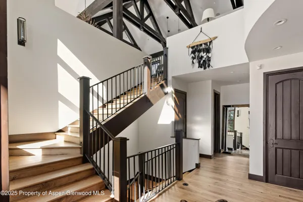 a view of staircase with lots of frames on wall and a chandelier