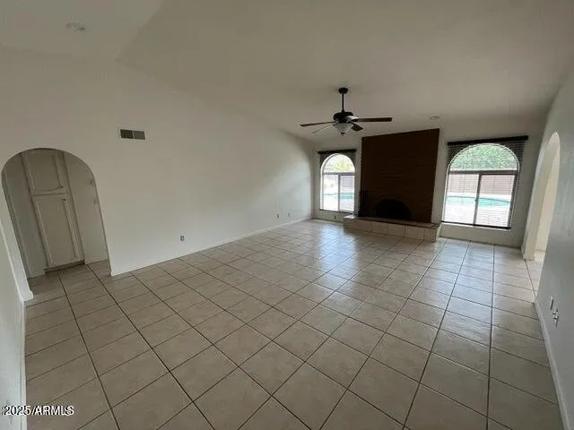 an empty room with windows and fireplace