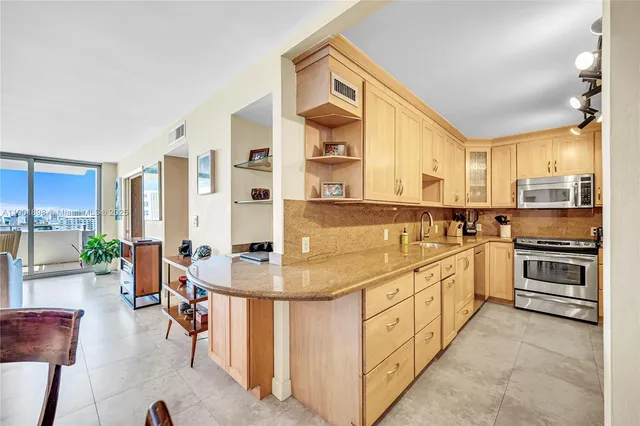 a kitchen with cabinets stainless steel appliances and sink