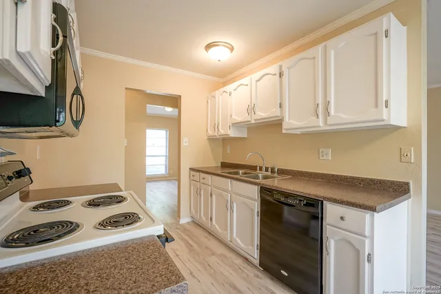 a kitchen with granite countertop cabinets stainless steel appliances and wooden floor
