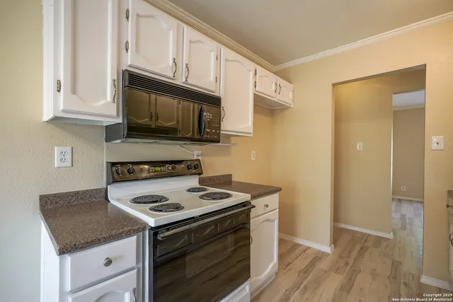 a kitchen with sink a stove and cabinets