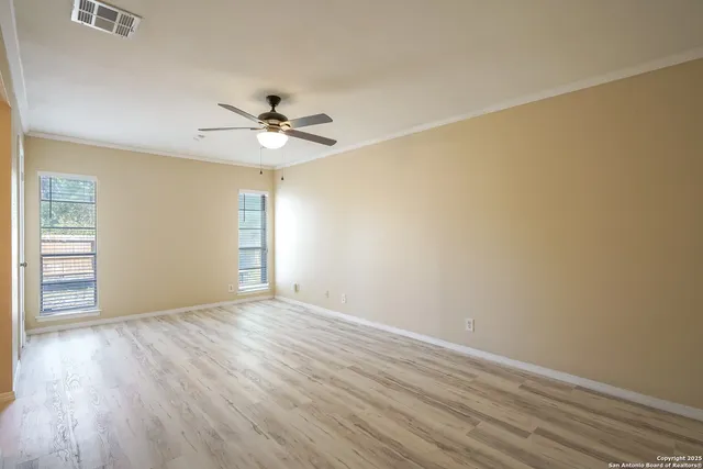 a view of a room with wooden floor and a ceiling fan