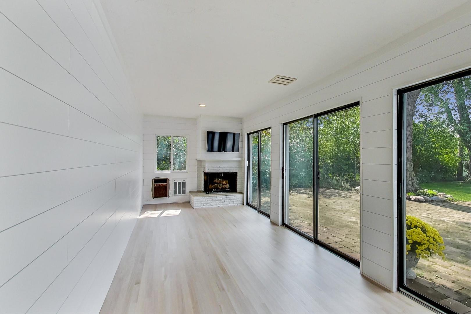 815 Locust Road Wilmette, IL 60091 - Photo 7 of 23 a view of an empty room with a fireplace and large windows