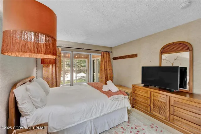 a bedroom with a bed and a flat screen tv