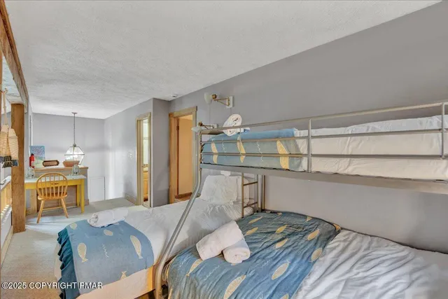 a bedroom with a bed and a large mirror on the dresser