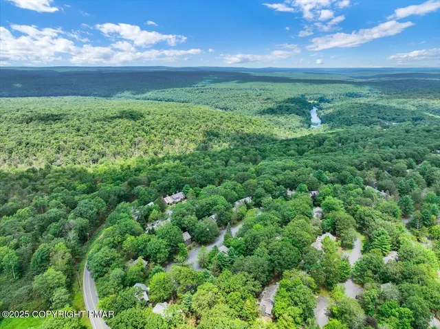 an aerial view of residential houses with outdoor space and trees