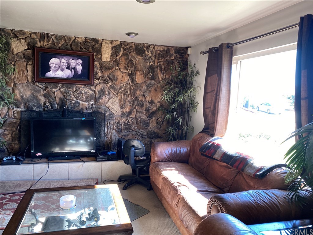 4684 Olive Street Montclair, CA 91763 - Photo 2 of 13 a living room with furniture a flat screen tv and a fireplace