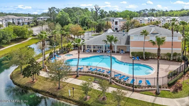 an aerial view of a house with swimming pool and lake view