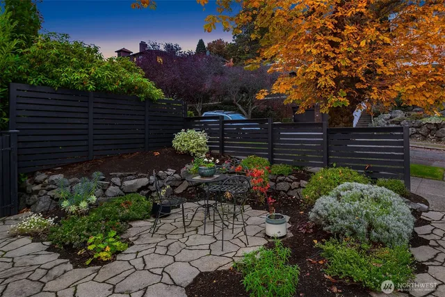 a garden with flowers and wooden fence