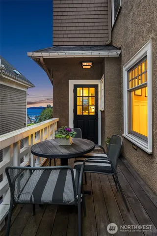 a view of a patio with table and chairs with wooden floor and fence