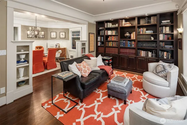 a living room with furniture a rug and a bookshelf