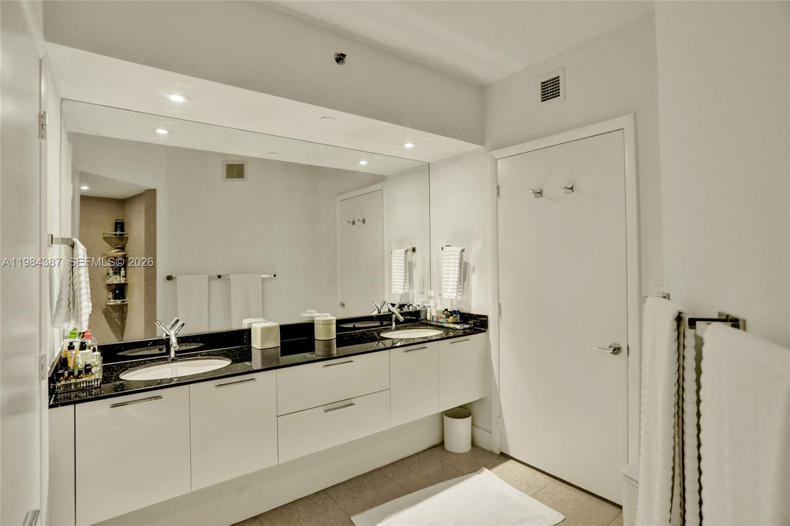 400 Alton Road, Unit 911 Miami Beach, FL 33139 - Photo 22 of 47 a bathroom with a double vanity sink and mirror