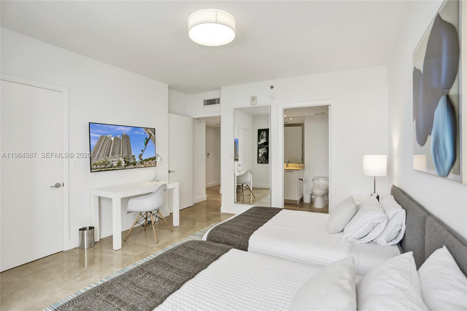 400 Alton Road, Unit 911 Miami Beach, FL 33139 - Photo 31 of 47 a bedroom with furniture and a flat screen tv