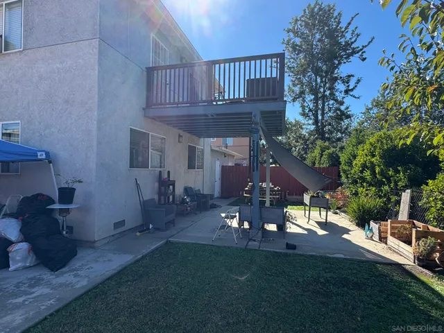 a view of a patio with table and chairs with wooden fence and plants