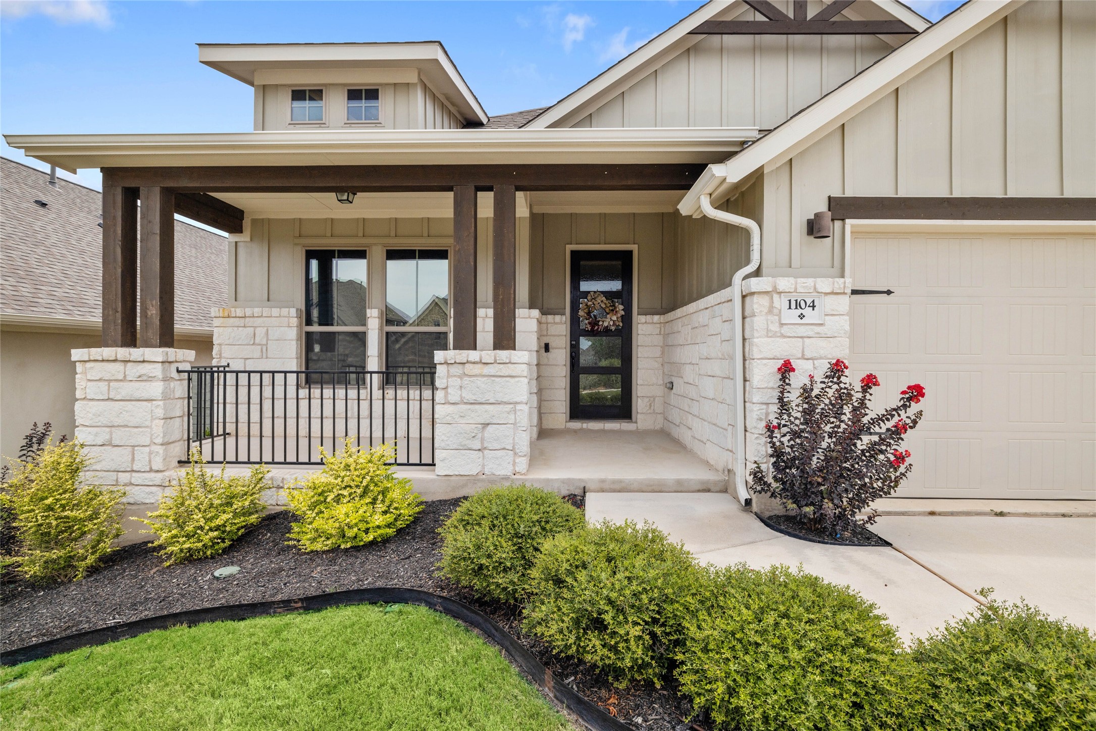 1104 River Vista Road Georgetown, TX 78628 - Photo 1 of 1 Property entrance with stone siding, board and batten siding, covered porch, and an attached garage