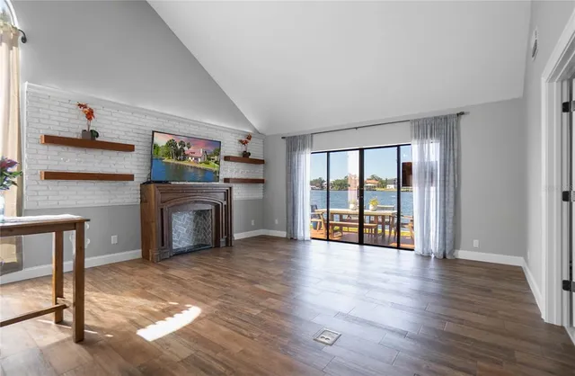 a dining room with wooden floor and kitchen view
