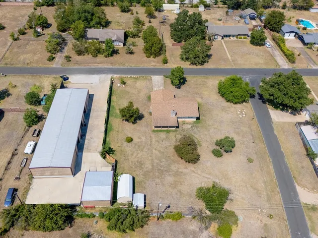 an aerial view of a house with a yard and lake view