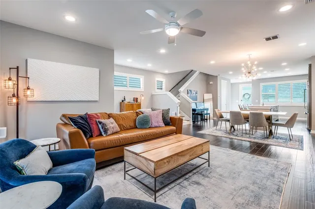 a living room with furniture kitchen view and a chandelier