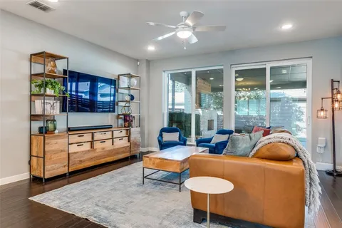 a living room with furniture a ceiling fan and a rug