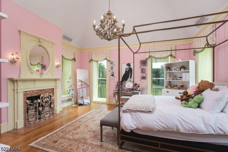 450 Claremont Road Bernardsville, NJ 07924 - Photo 31 of 47 a bedroom with a bed a chandelier and a fireplace