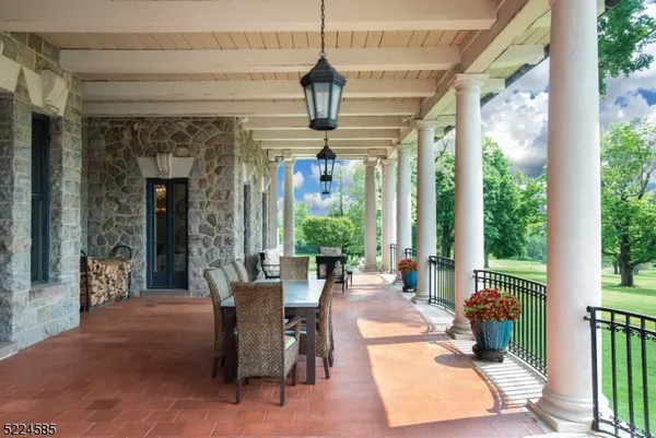 a view of a patio with table and chairs and a barbeque
