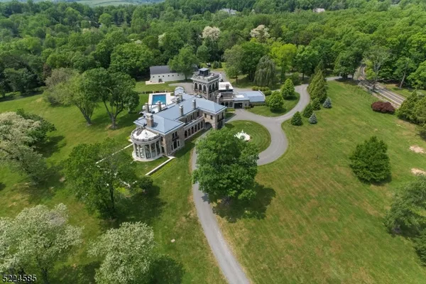 an aerial view of a house with a yard basket ball court and trampoline