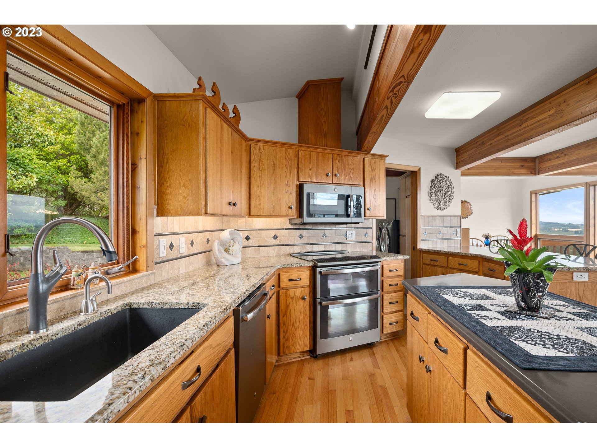 30875 Southwest Laurelview Road Hillsboro, OR 97123 - Photo 17 of 36 a kitchen with stainless steel appliances granite countertop a sink a stove cabinets counter space and a window
