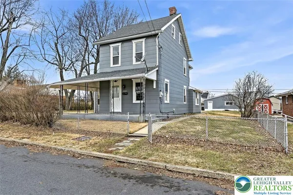 a view of a house with snow on the side of the road