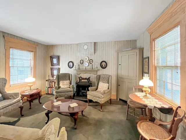 a living room with furniture couches and a large window with garden view