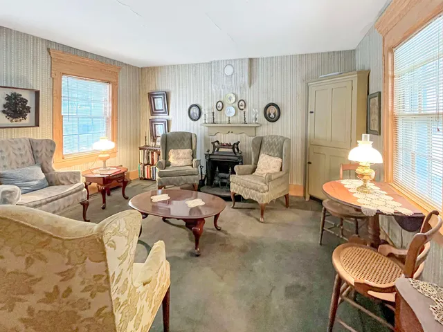 a living room with fireplace furniture and a large window