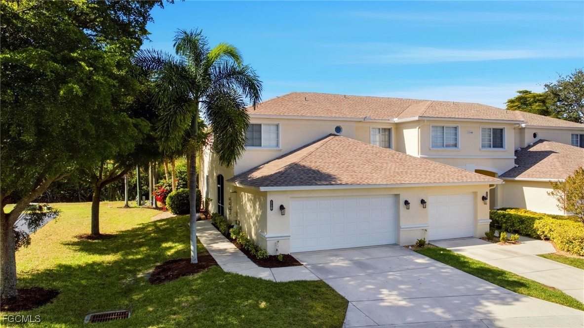 13160 Broadhurst Loop, Unit 101 Fort Myers, FL 33919 - Photo 1 of 39 a view of a white house with a yard plants and large tree